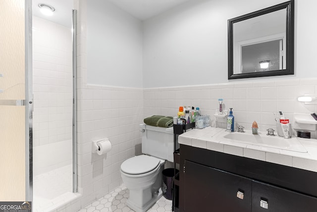 full bath featuring tile walls, toilet, wainscoting, a shower stall, and vanity