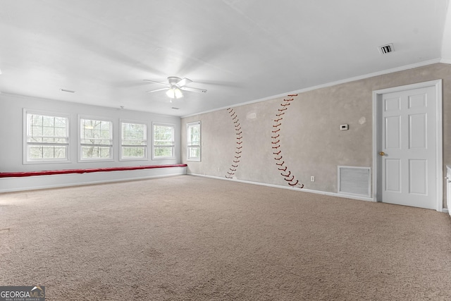 carpeted empty room featuring ornamental molding, visible vents, ceiling fan, and baseboards