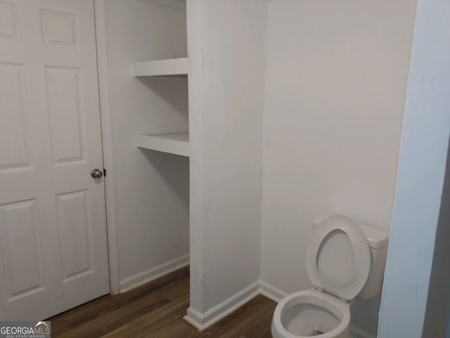 bathroom featuring toilet, baseboards, and wood finished floors