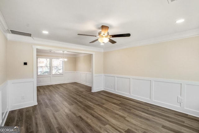 spare room featuring visible vents, ornamental molding, dark wood-style flooring, and ceiling fan with notable chandelier