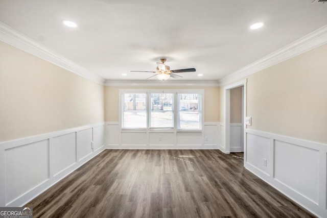 unfurnished room with dark wood finished floors, a ceiling fan, wainscoting, ornamental molding, and recessed lighting