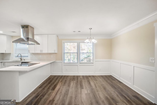 kitchen with light countertops, hanging light fixtures, white cabinets, island range hood, and black electric cooktop