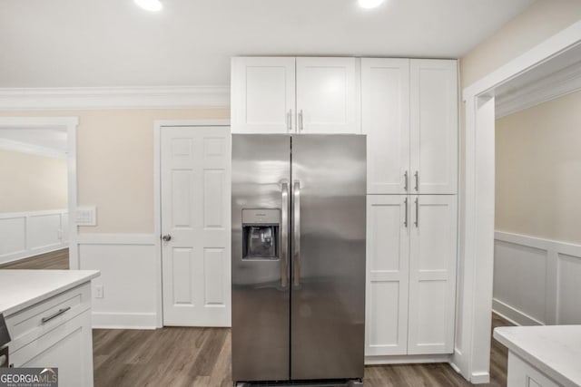 kitchen featuring ornamental molding, dark wood-type flooring, stainless steel fridge, and white cabinets