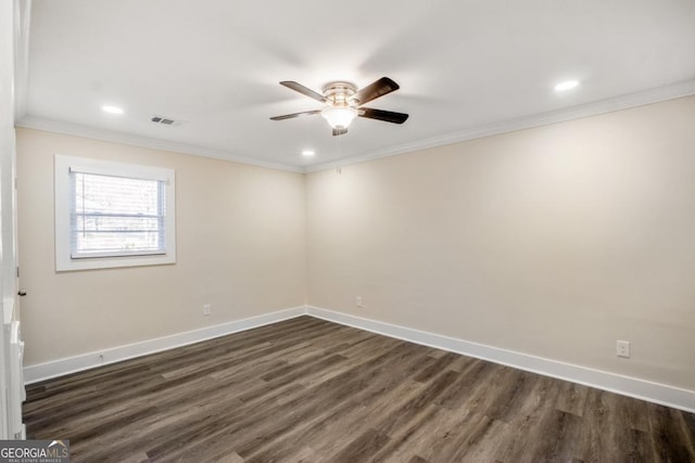 spare room featuring baseboards, dark wood-style floors, visible vents, and crown molding