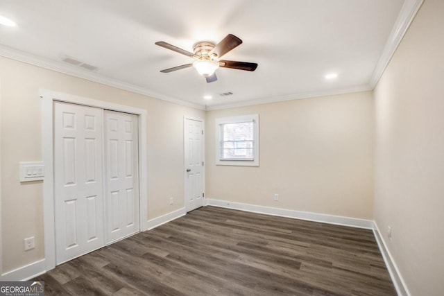 unfurnished bedroom with baseboards, visible vents, dark wood-style flooring, and crown molding