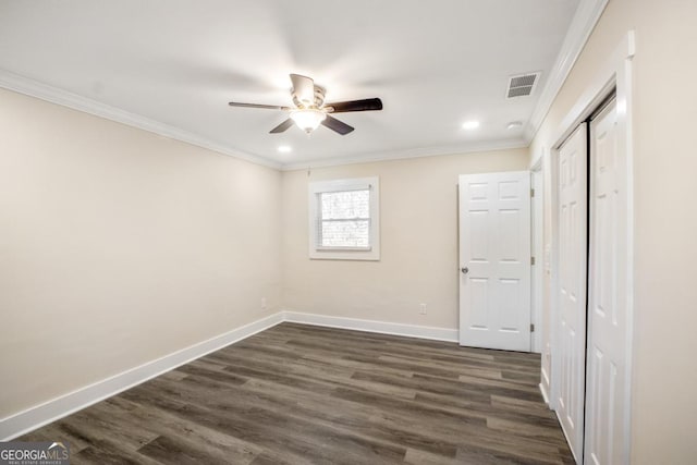 unfurnished bedroom with dark wood-style floors, crown molding, visible vents, a ceiling fan, and baseboards