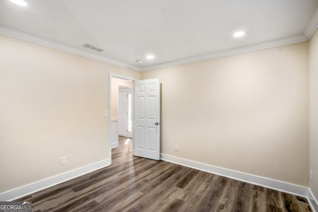 unfurnished room with ornamental molding, dark wood finished floors, visible vents, and baseboards