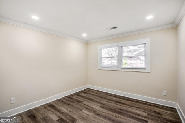 unfurnished room with baseboards, dark wood-style floors, visible vents, and crown molding