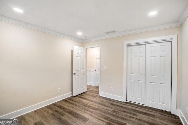 unfurnished bedroom with dark wood-style flooring, visible vents, and baseboards