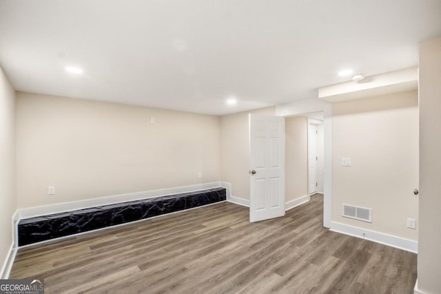 exercise room with baseboards, visible vents, and wood finished floors