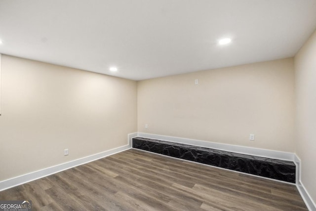 empty room featuring baseboards, wood finished floors, and recessed lighting