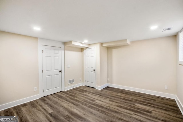 finished below grade area featuring dark wood-style floors, baseboards, visible vents, and recessed lighting