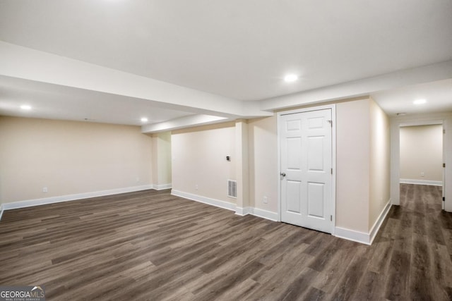 finished basement with baseboards, visible vents, dark wood finished floors, and recessed lighting