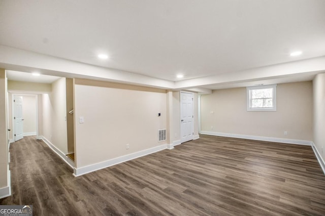 basement featuring dark wood-style floors, recessed lighting, visible vents, and baseboards