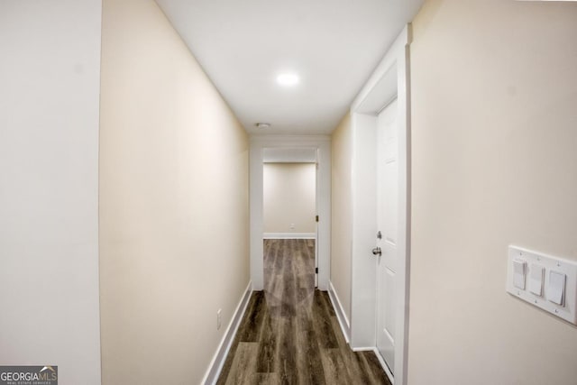 hall featuring dark wood-style floors and baseboards