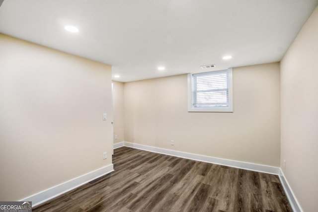 basement with dark wood-style flooring, recessed lighting, visible vents, and baseboards