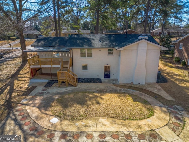 back of house featuring brick siding, stairway, a patio area, and a wooden deck