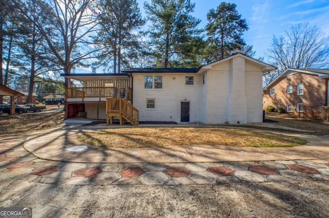 rear view of house with stairs and brick siding