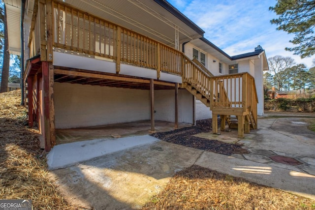 rear view of property with a wooden deck and stairs