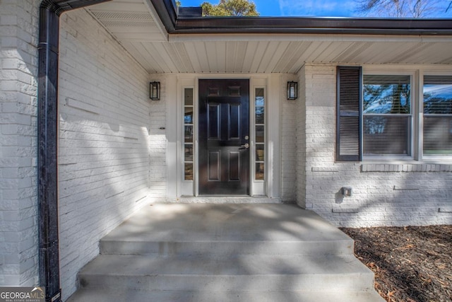 view of exterior entry featuring brick siding