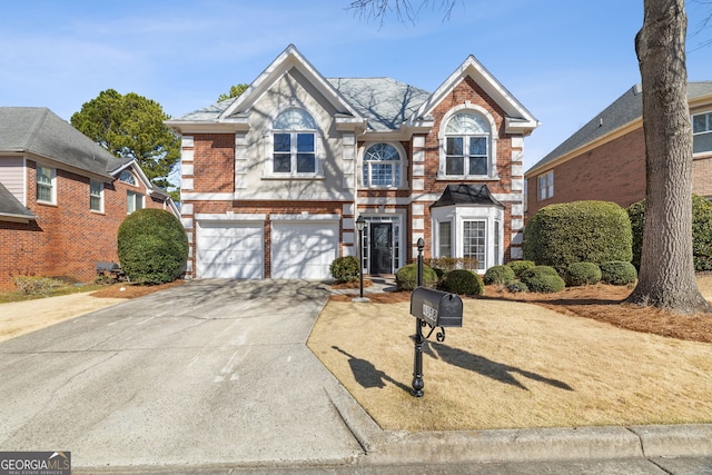 traditional-style house featuring driveway, brick siding, and an attached garage