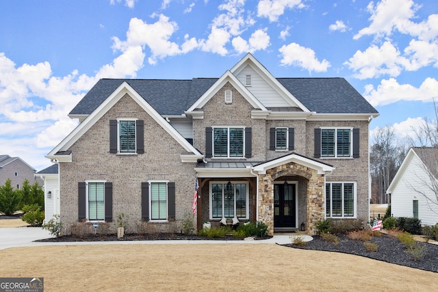 view of front facade with brick siding, a front lawn, and a shingled roof