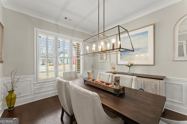 dining room with dark wood finished floors, wainscoting, and a healthy amount of sunlight