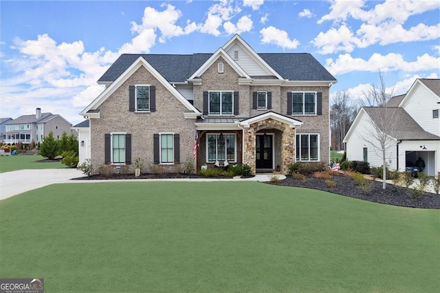 view of front of home with brick siding, a front lawn, and a shingled roof