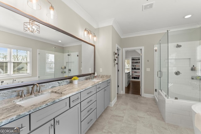 full bathroom featuring a stall shower, double vanity, a sink, and ornamental molding