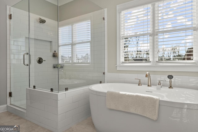 bathroom with a stall shower, a healthy amount of sunlight, and tile patterned flooring