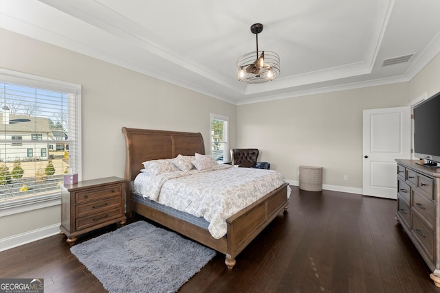 bedroom with dark wood-type flooring, visible vents, baseboards, and a raised ceiling