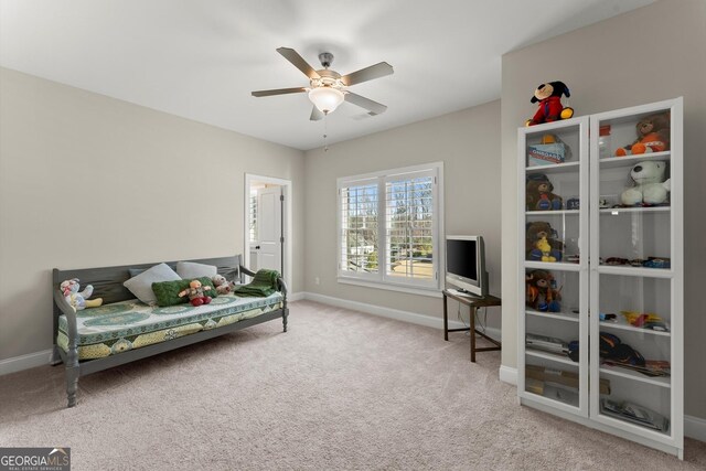 living area with carpet flooring, visible vents, baseboards, and a ceiling fan