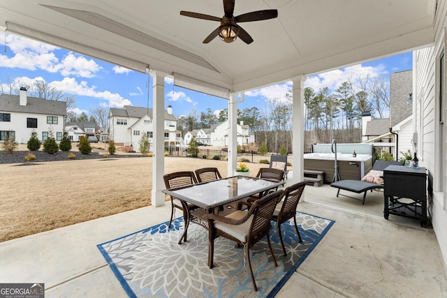 view of patio with outdoor dining space, a residential view, a hot tub, and ceiling fan