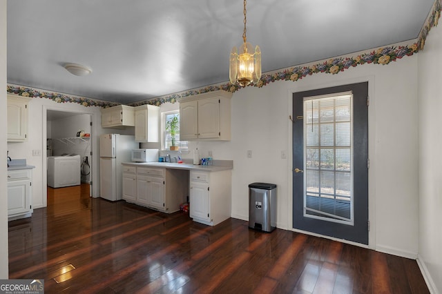 kitchen with white appliances, light countertops, dark wood-type flooring, and washer / dryer