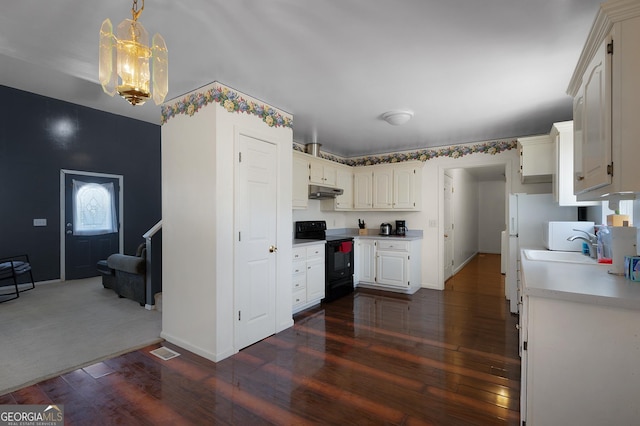 kitchen with light countertops, dark wood-style flooring, black range with electric cooktop, and under cabinet range hood