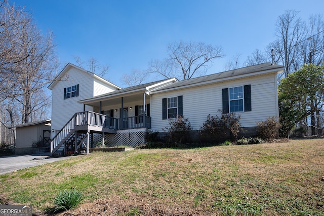 view of front of property featuring covered porch, stairway, and a front yard