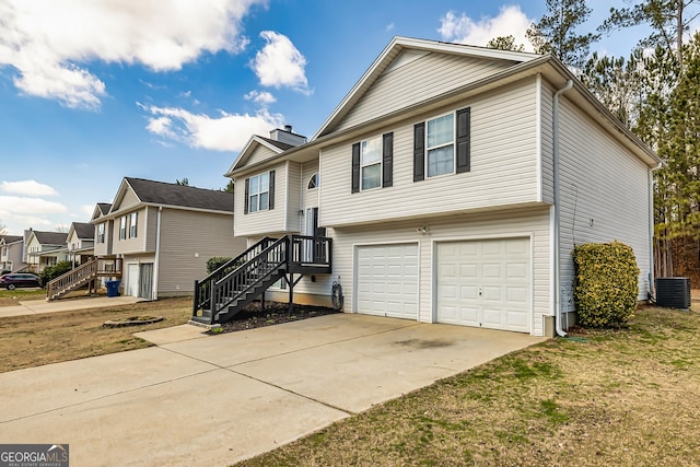 split foyer home with an attached garage, central AC, driveway, stairway, and a front lawn