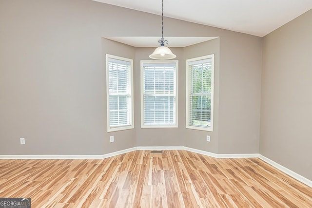 empty room with lofted ceiling, baseboards, and wood finished floors