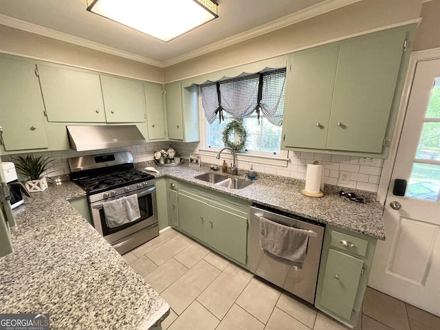 kitchen with crown molding, tasteful backsplash, appliances with stainless steel finishes, a sink, and under cabinet range hood