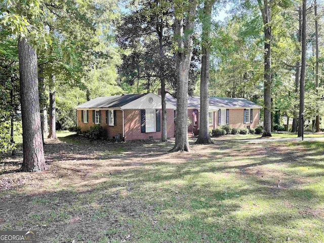 single story home featuring brick siding and a front lawn