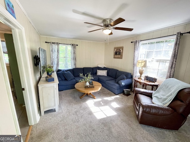 living area featuring light carpet, a ceiling fan, and crown molding