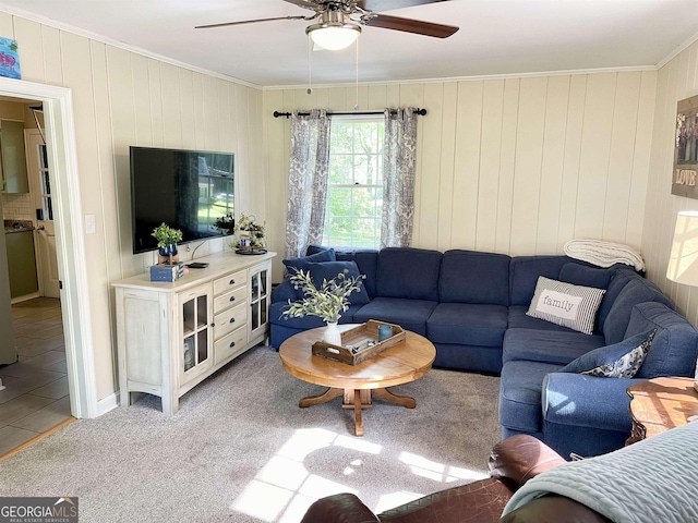 living room with light carpet, light tile patterned floors, a ceiling fan, and crown molding