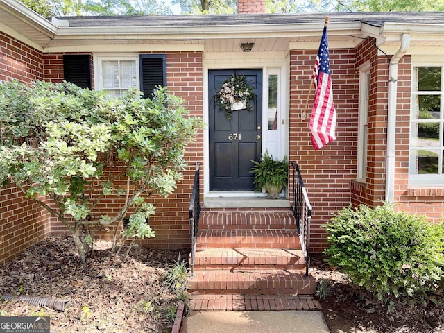 property entrance with brick siding and a chimney