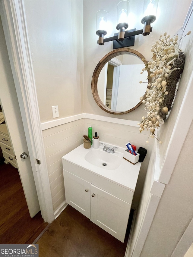 bathroom with wainscoting, wood finished floors, and vanity