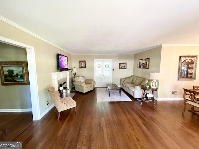 living room with dark wood-style floors, a fireplace with flush hearth, baseboards, and crown molding