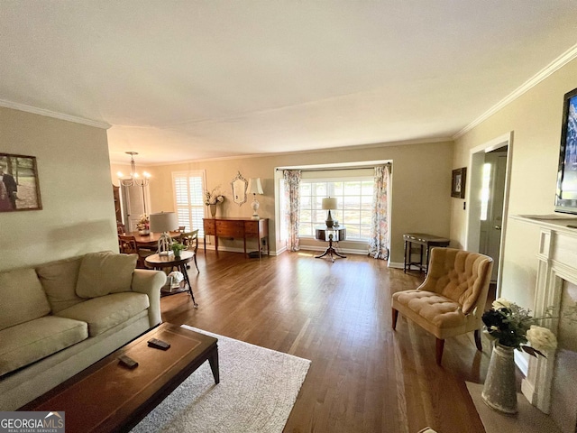 living room featuring dark wood-style floors, ornamental molding, baseboards, and a notable chandelier