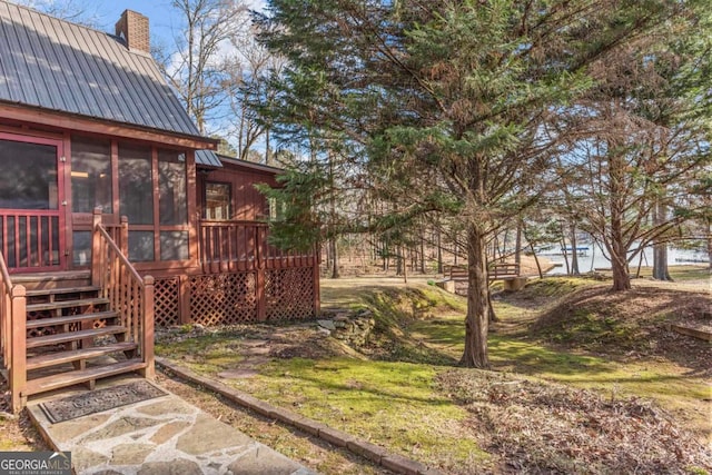 view of yard featuring a sunroom and stairs