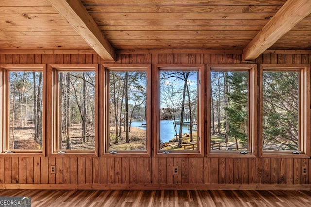 unfurnished sunroom featuring wood ceiling, a water view, and beam ceiling