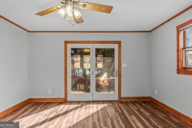 interior space with crown molding, baseboards, and wood finished floors