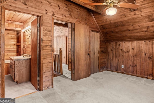 additional living space with wood walls, wooden ceiling, and light colored carpet